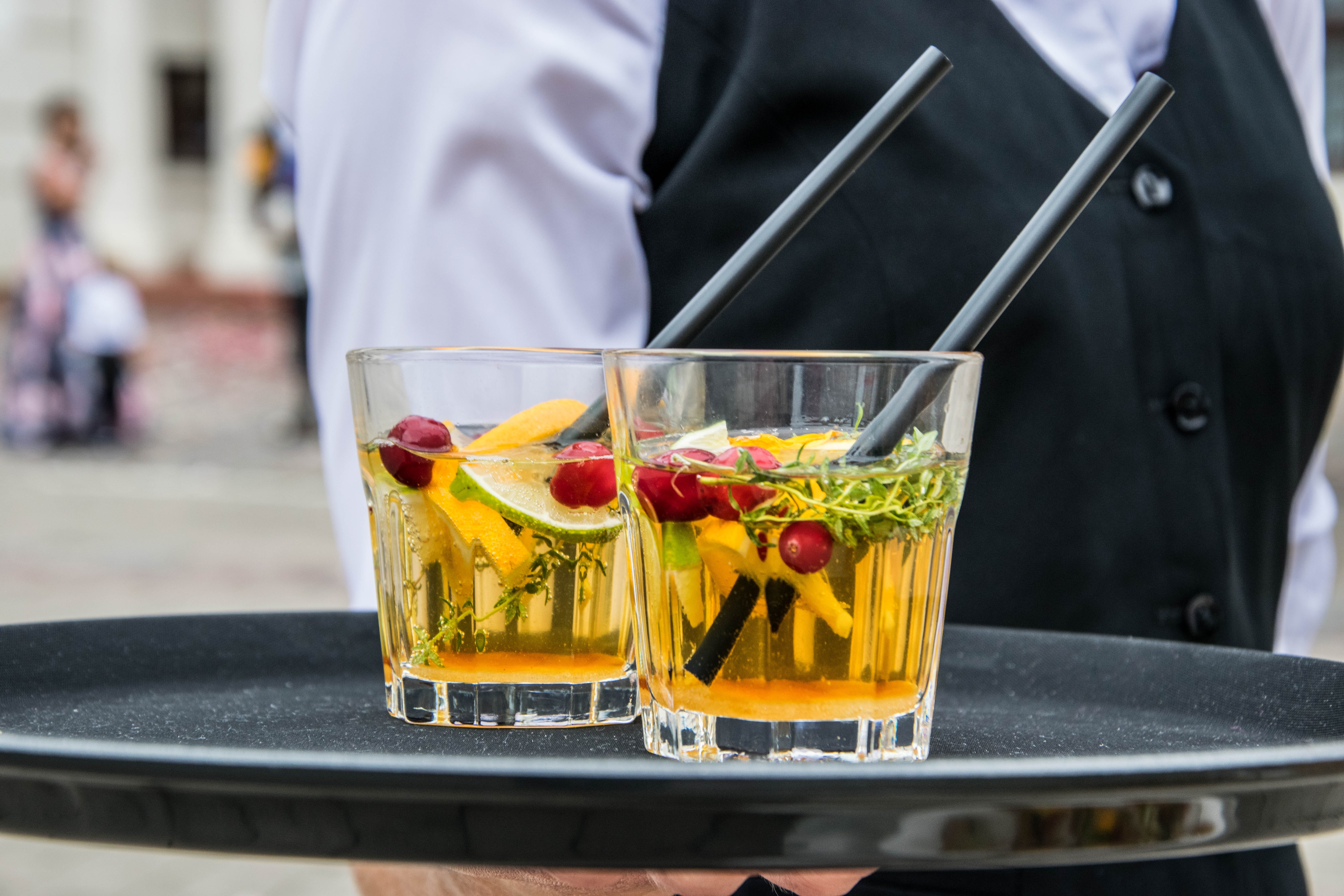 Two cocktailglasses filled with a drink and fruits.