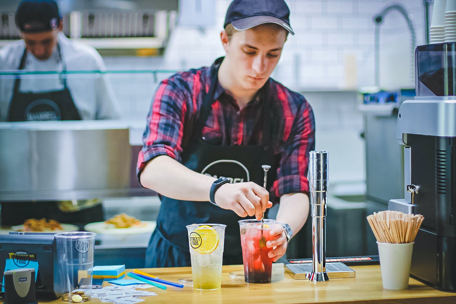 Bartender mixing two drinks behind the bar.